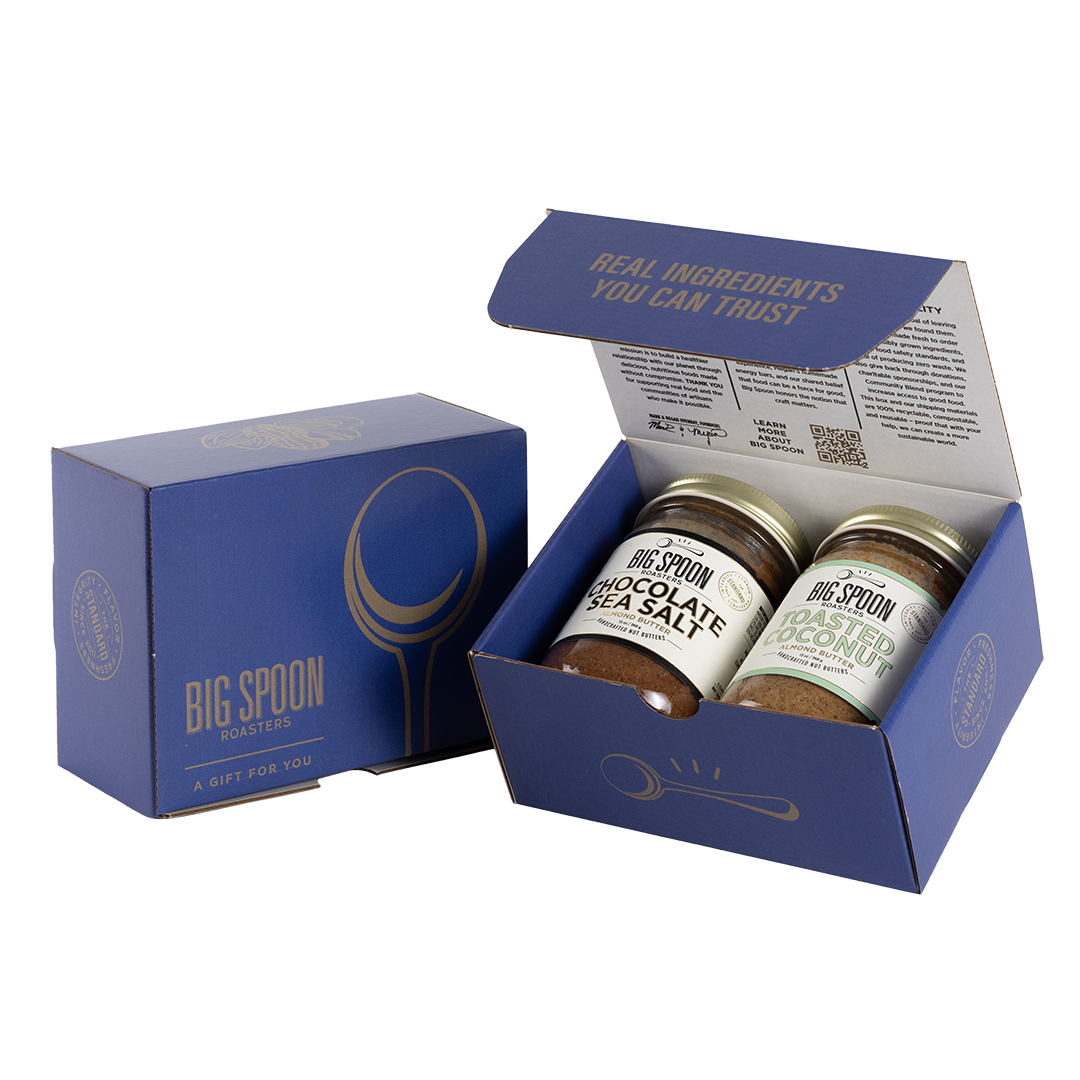 Blue gift box with two jars of Big Spoon Roasters nut butter next to a closed blue gift box