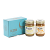 Two jars of Big Spoon Roasters nut butter in front of a closed blue gift box
