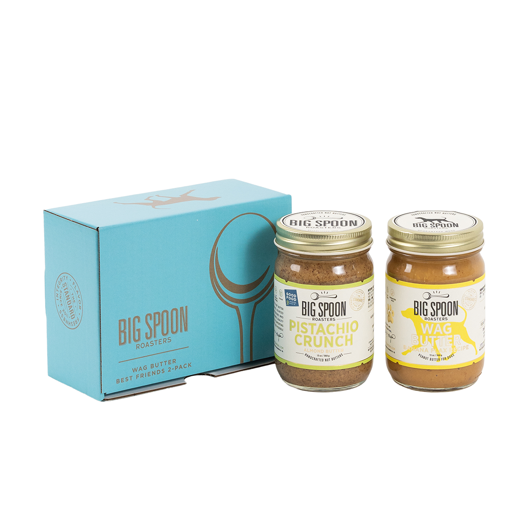 Two jars of Big Spoon Roasters nut butter in front of a closed blue gift box