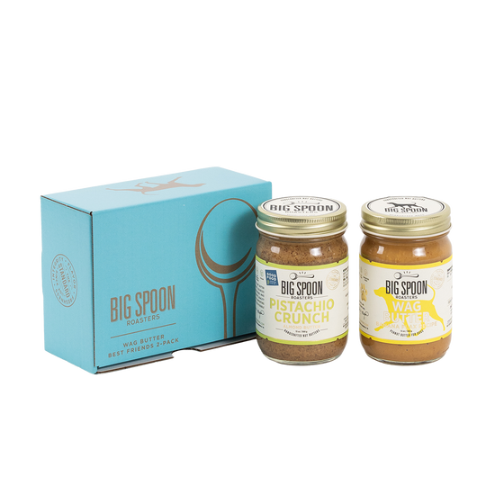 Two jars of Big Spoon Roasters nut butter in front of a closed blue gift box