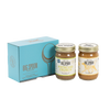 Two jars of Big Spoon Roasters nut butter in front of a closed blue gift box