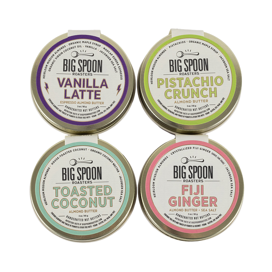 Four tins of Big Spoon Roasters almond butter with different flavors on a white background