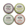 Four tins of Big Spoon Roasters almond butter with different flavors on a white background
