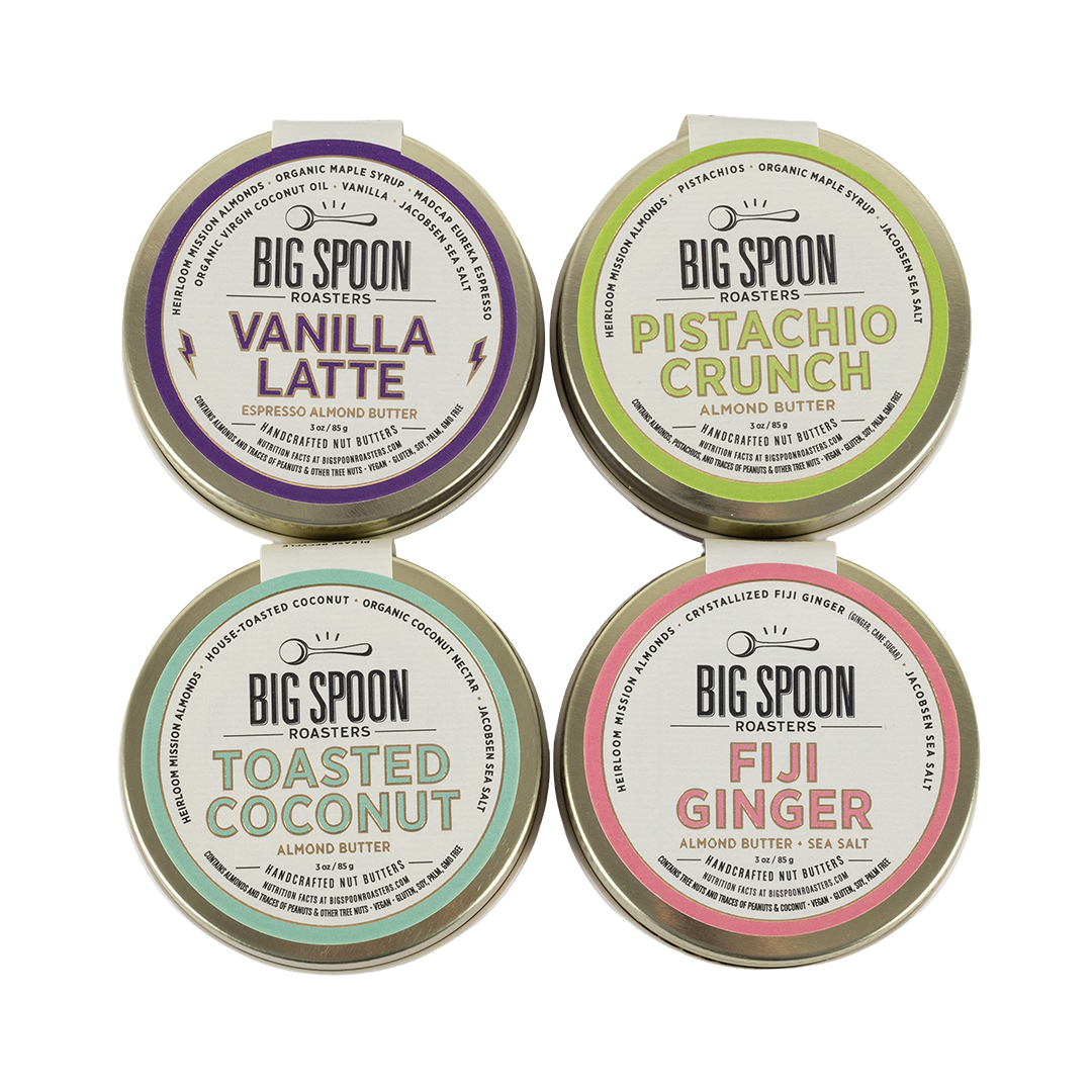 Four tins of Big Spoon Roasters almond butter with different flavors on a white background