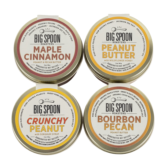 Four tins of Big Spoon Roasters peanut butter on a white background