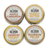 Four tins of Big Spoon Roasters peanut butter on a white background