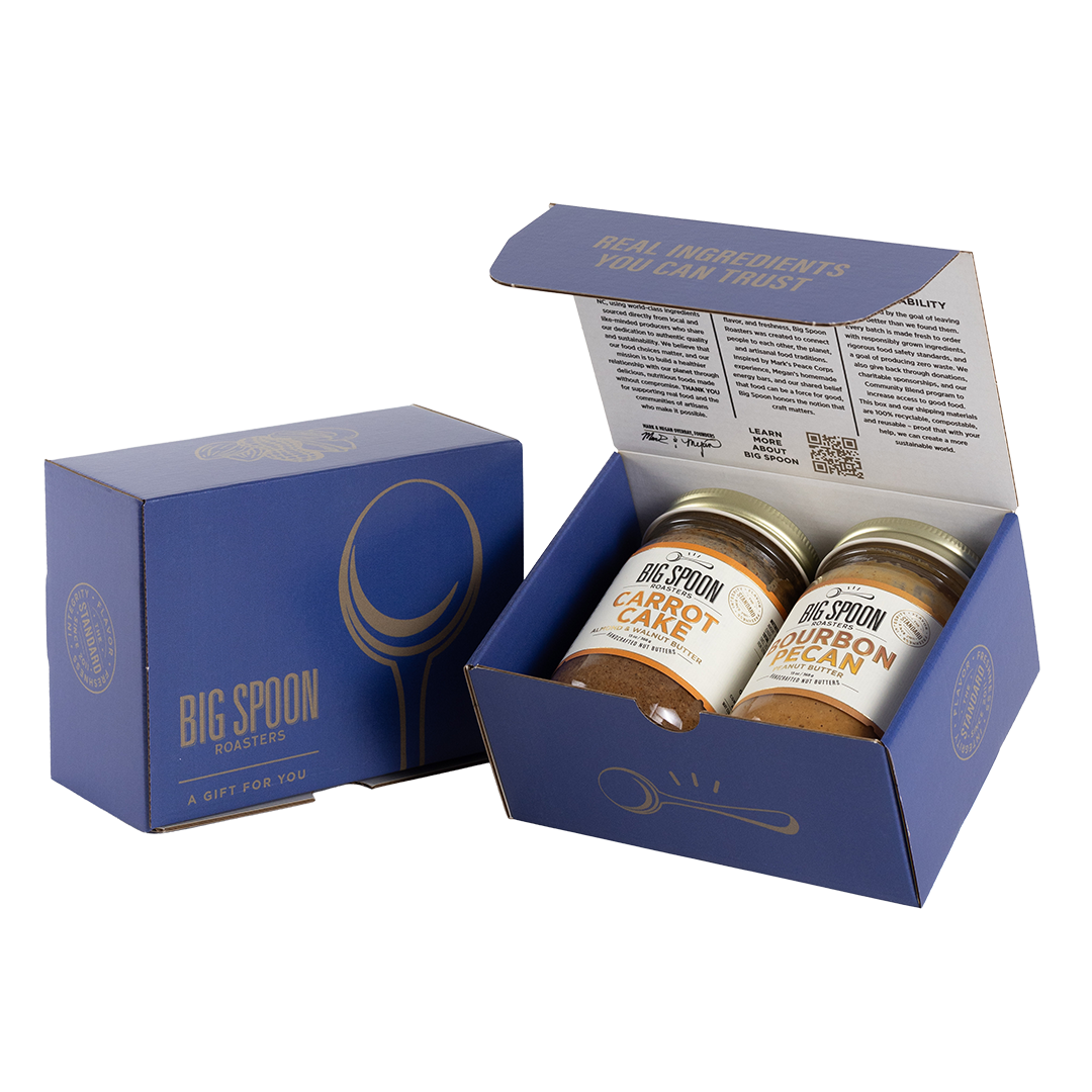 Blue gift box with two jars of Big Spoon Roasters nut butter next to a closed blue gift box
