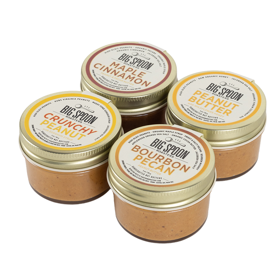 Four jars of Big Spoon Peanut Butter on a white background
