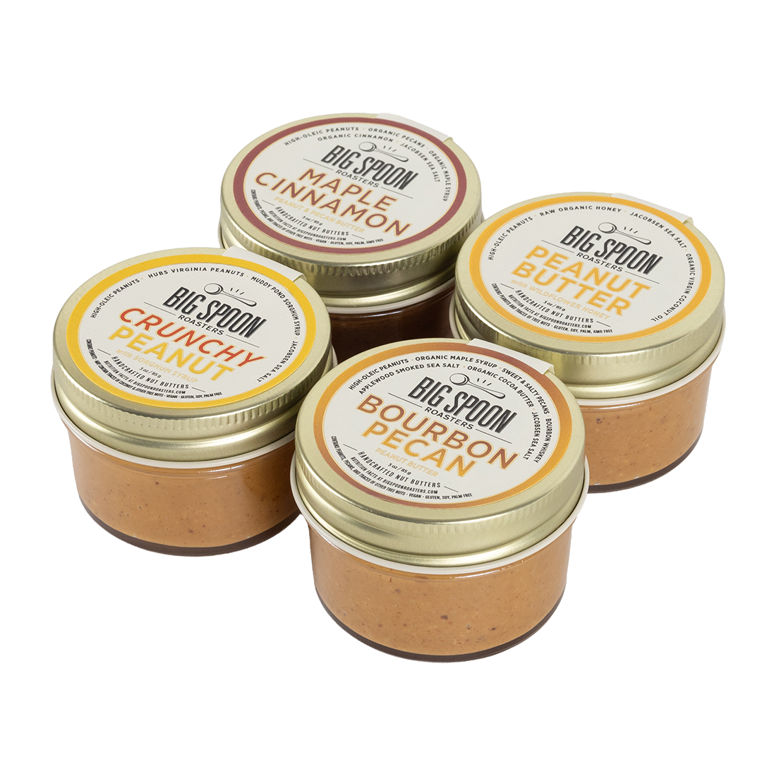 Four jars of Big Spoon Peanut Butter on a white background
