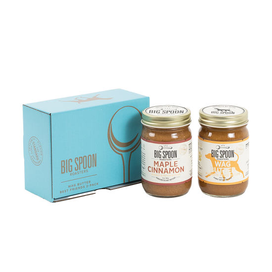 Two jars of Big Spoon Roasters nut butter in front of a closed blue gift box