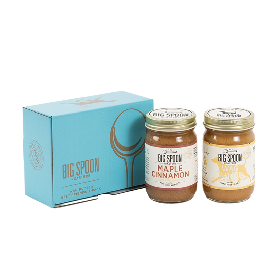 Two jars of Big Spoon Roasters nut butter in front of a closed blue gift box