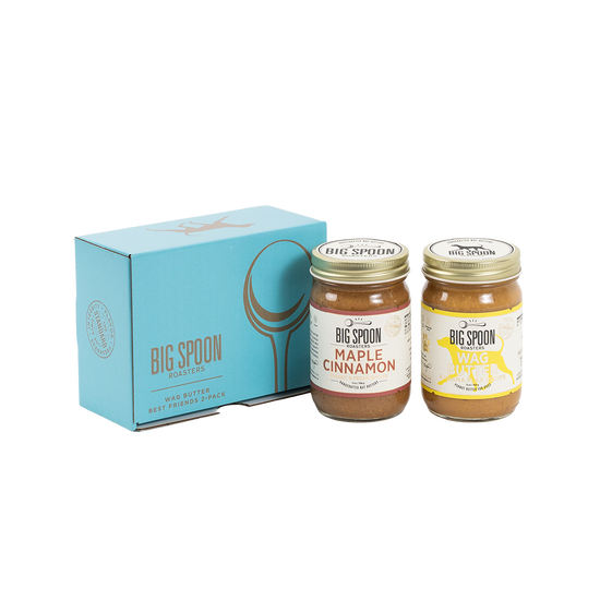 Two jars of Big Spoon Roasters nut butter in front of a closed blue gift box